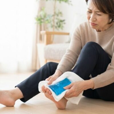 ぶつけた足の指を保冷剤で冷やしている女性のイメージ