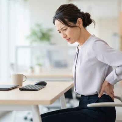 座り仕事で腰の痛みに悩む女性のイメージ