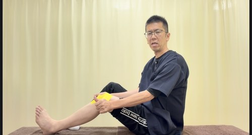 膝を伸ばした状態でお皿の上が真ん中になるようにテープを当てる様子