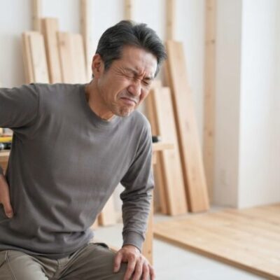 現場で腰を押さえる50代男性のイメージ